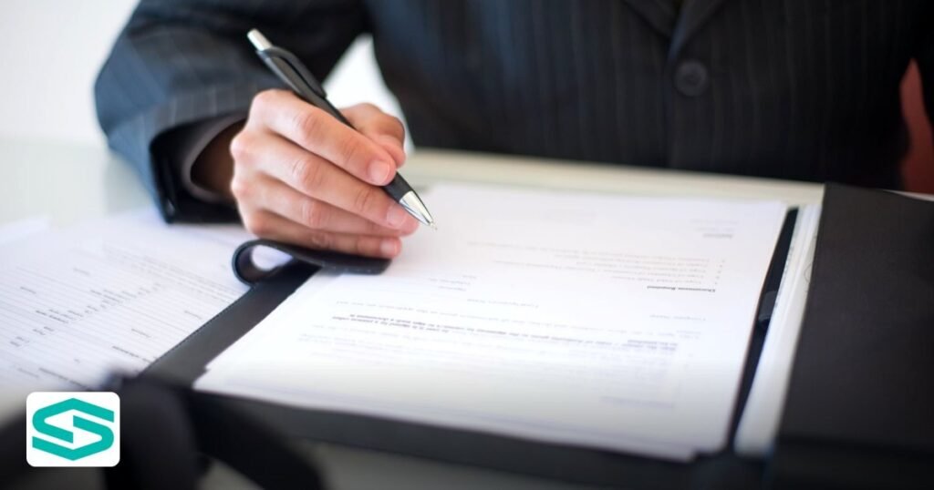 Startzone UAE Setup Guide - close-up of a hand signing documents with a pen