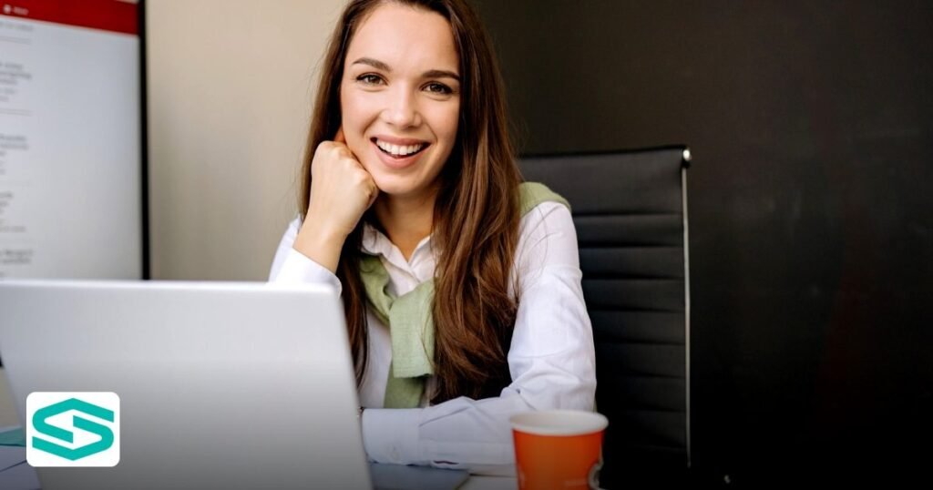 Cheapest smartzonesuae Packages for Tech Startups in 2026 - businesswoman sitting at desk in office, smiling at camera