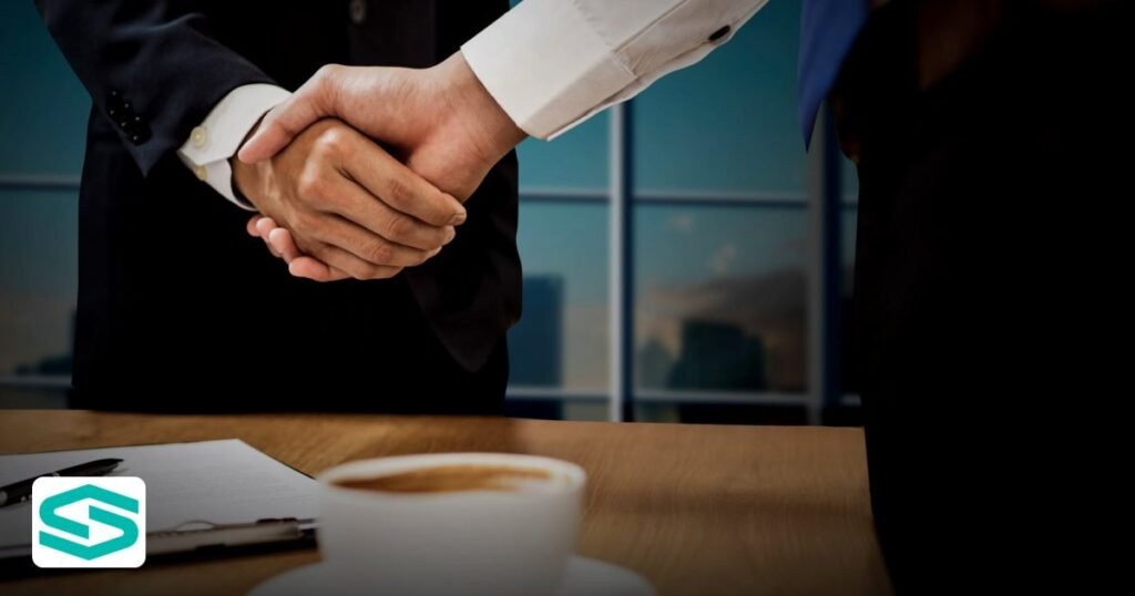 goaml registration uae: A clear guide for free‑zone businesses - two professionals shaking hands across a desk