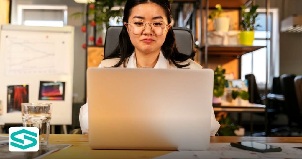 How Much Does It Cost to Set Up a Company in UAE Free Zone? - asian woman with eyeglasses working on a laptop in a modern