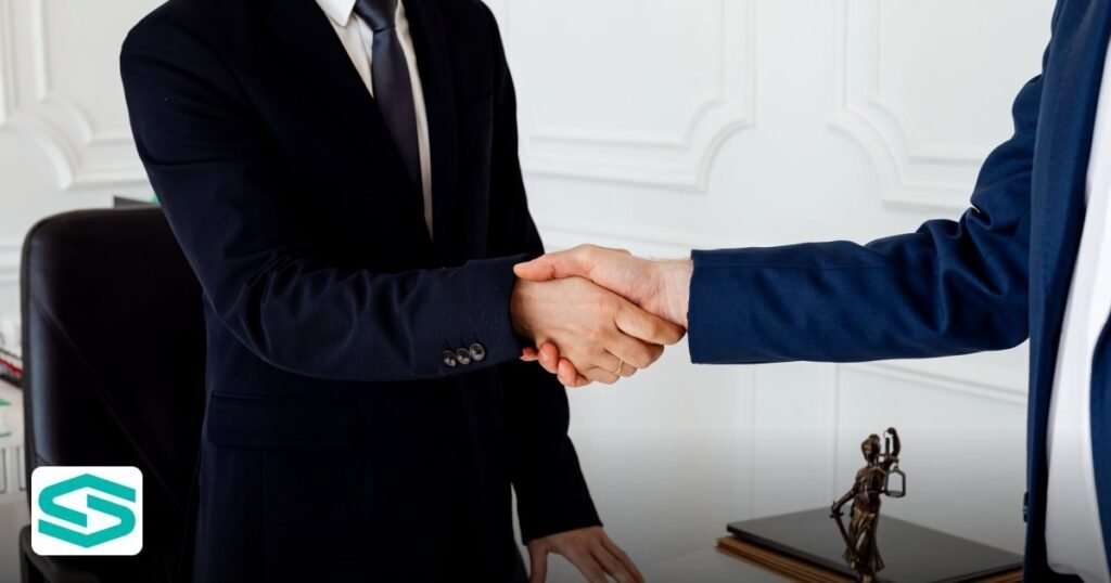 Noc Letter Free Zone: When It’s Needed and How to Request It - two men in suits shaking hands in a formal office environment