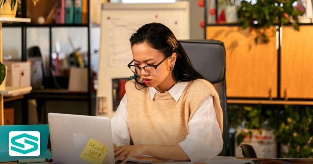 Startzone Review 2026: Licences, Fees & Visa Services - woman with glasses concentrating on laptop work in a stylish