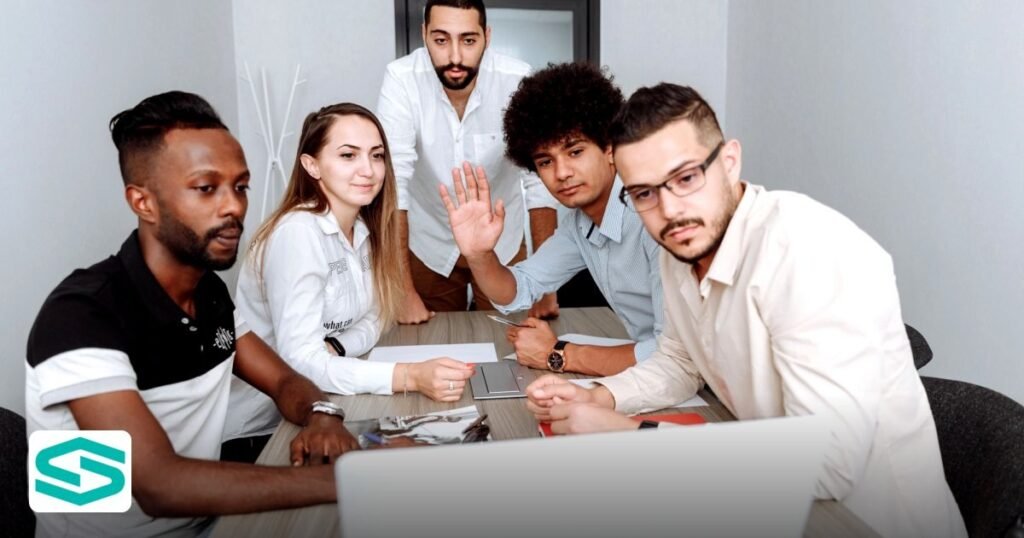 UAE Free Zone Employee Onboarding Checklist for 2026 Hires - diverse team collaborating around a laptop in a modern office