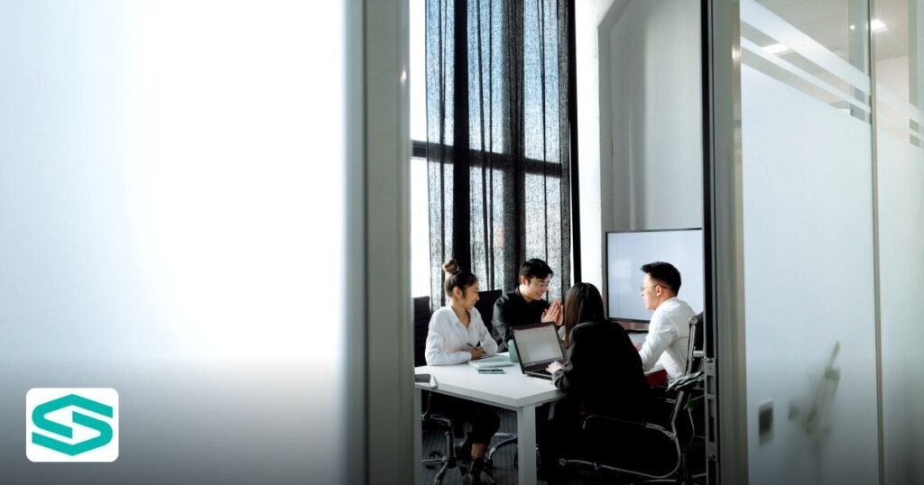 UAE Free Zone Crypto Banking Comparison – 2026 Update - group collaborating in a well-lit office room with large windows,
