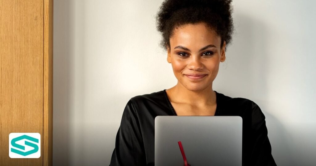 UAE Free Zone Luxury Fashion Expansion: 2026 Guide - confident woman indoors holding a laptop and smiling warmly